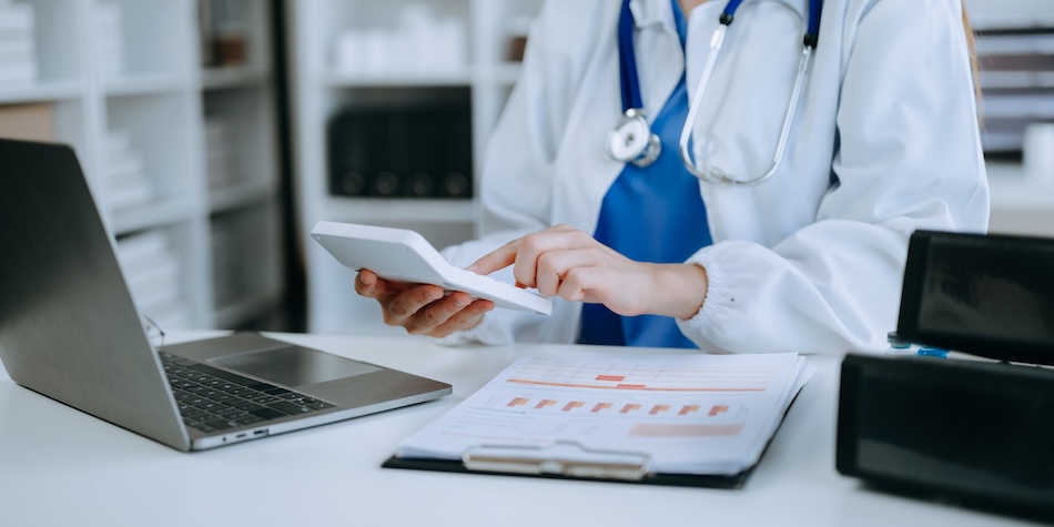 A doctor using a calculator at their desk