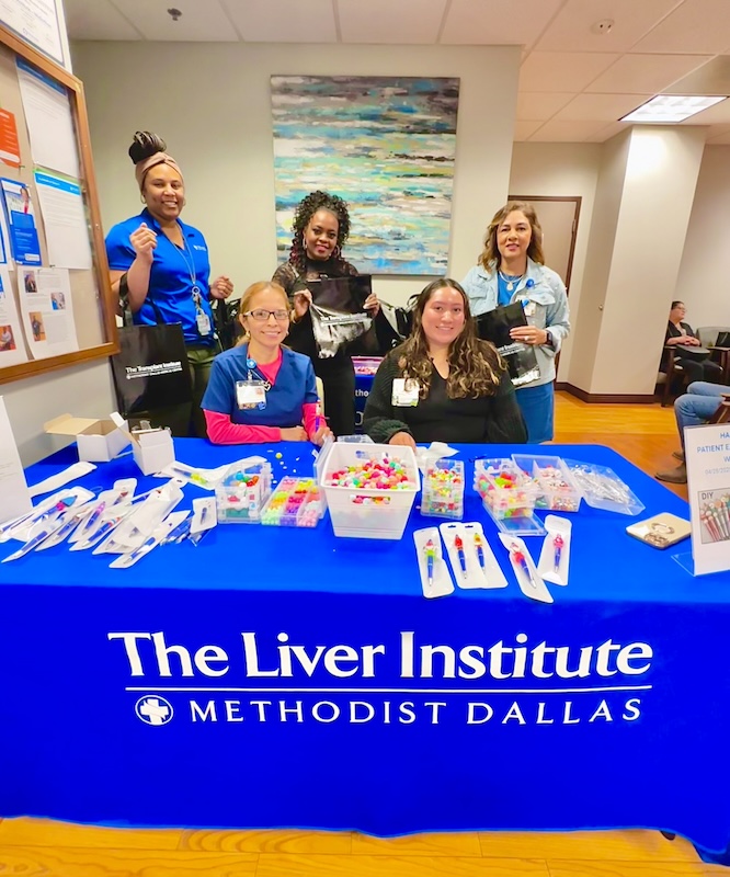 A group of employees at a DIY pen-making station in the lobby of the Liver Institute