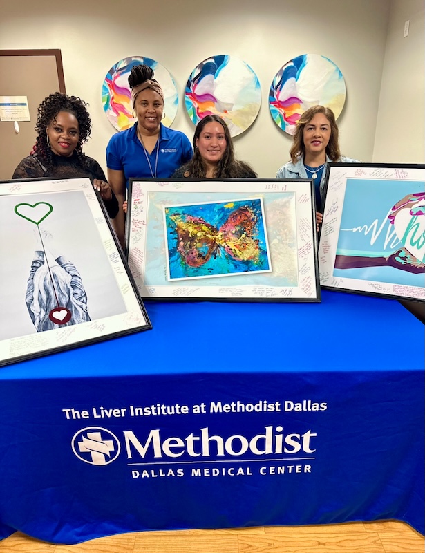 Some employees at the institute holding up paintings